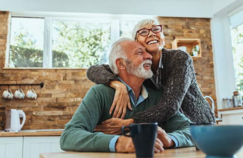 Senior couple hugging each other at home