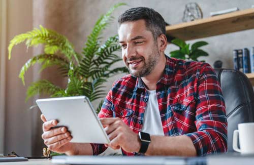 man looking at his tablet