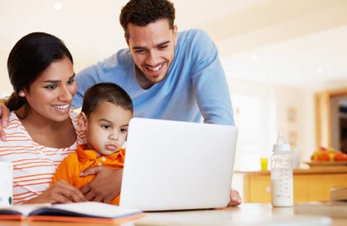 Family looking at their home laptop computer