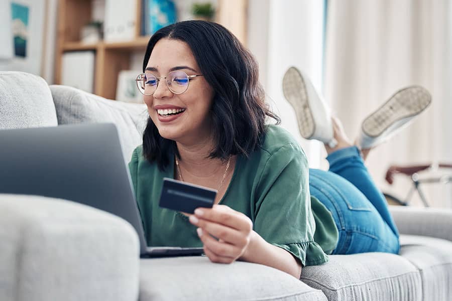 A woman using a credit card with her laptop