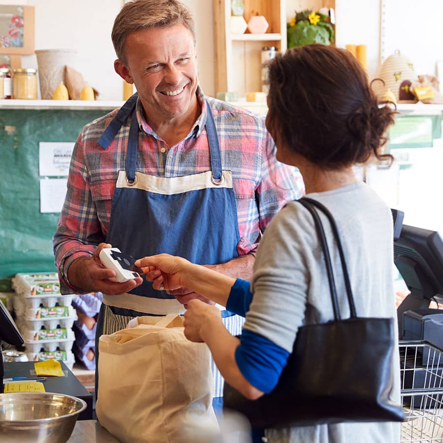 A shopkeeper rings up a customer