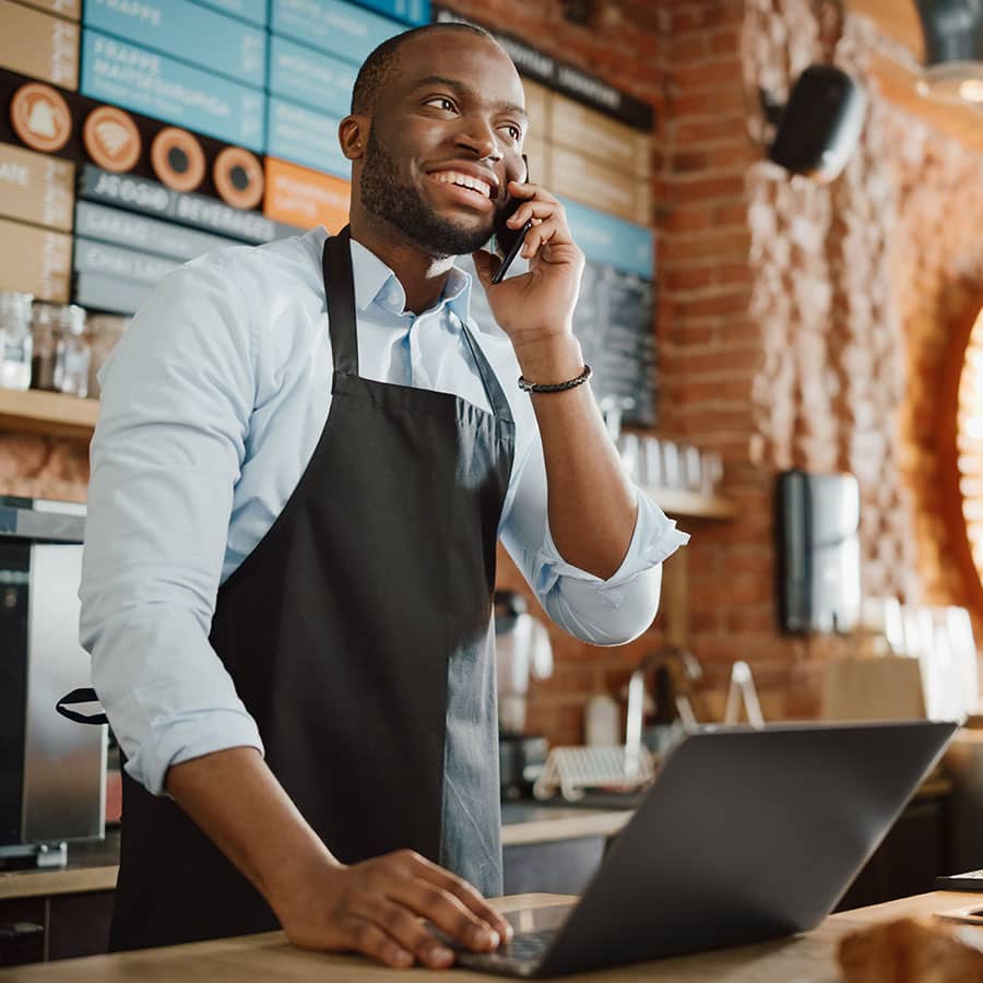 A man working at a cafe on the phone