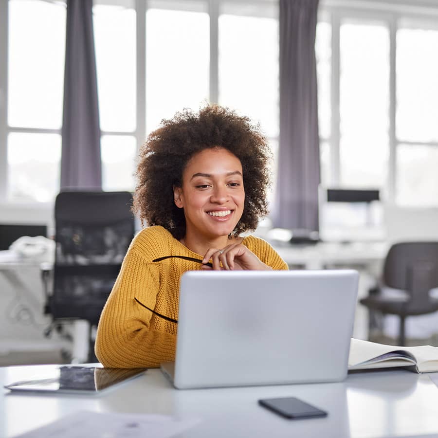 A businesswoman uses a laptop at her desk