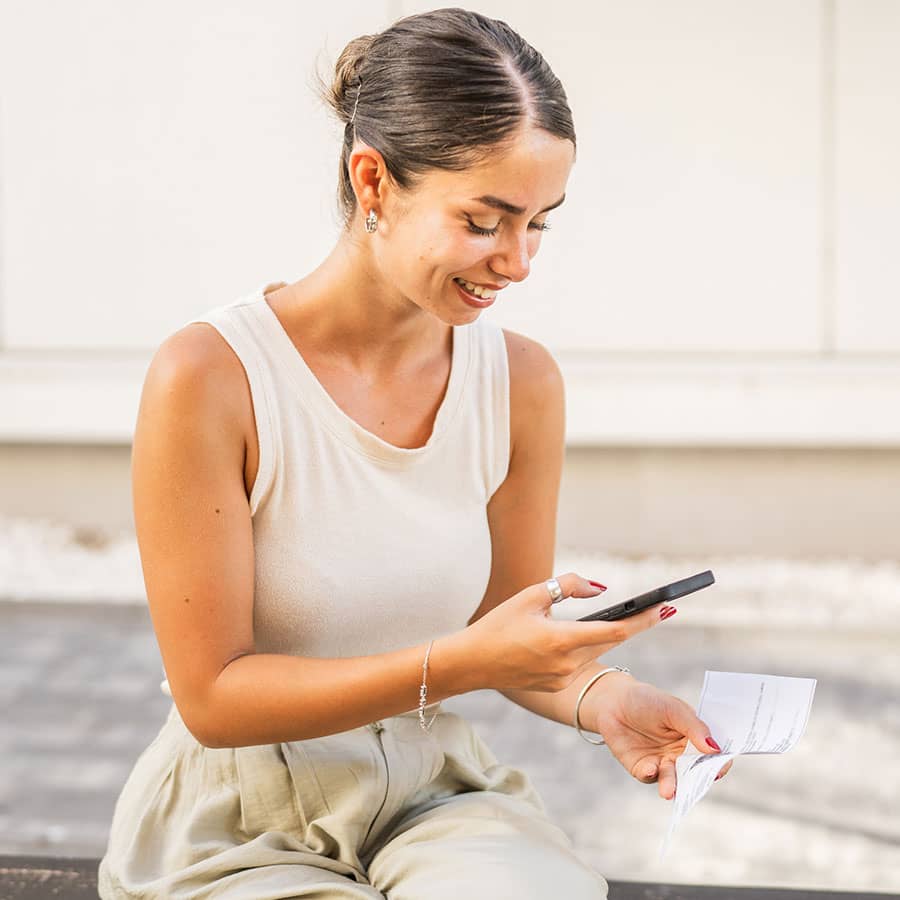A woman uses her phone to take a photo of a check