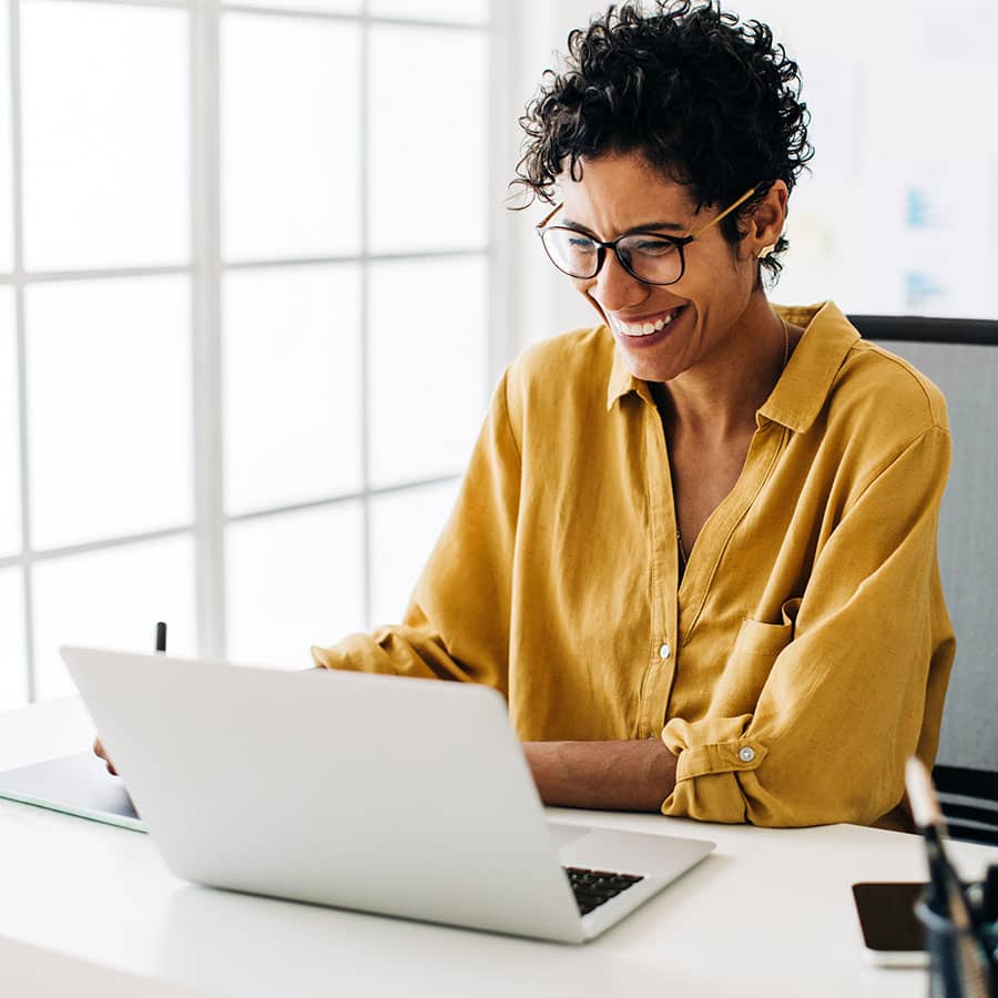 A business woman using a laptop at her desk