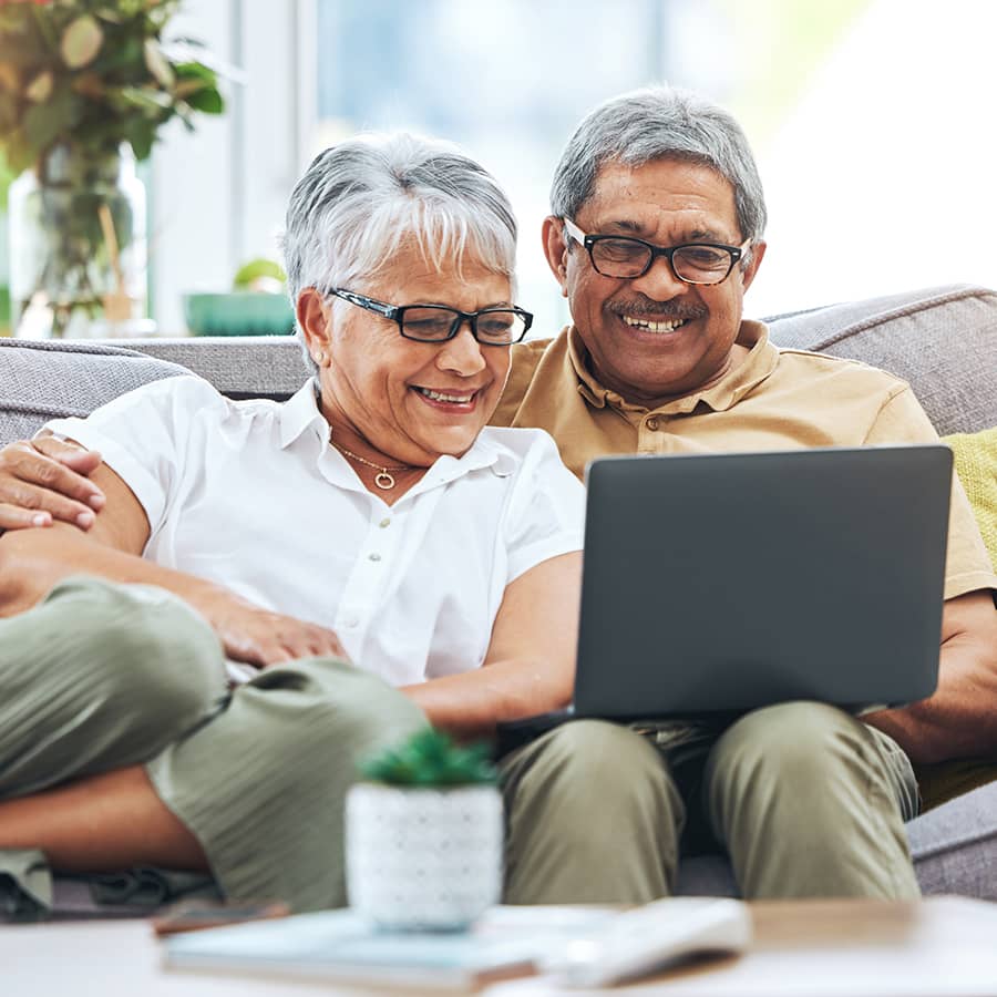 An older couple looking at a laptop screen together