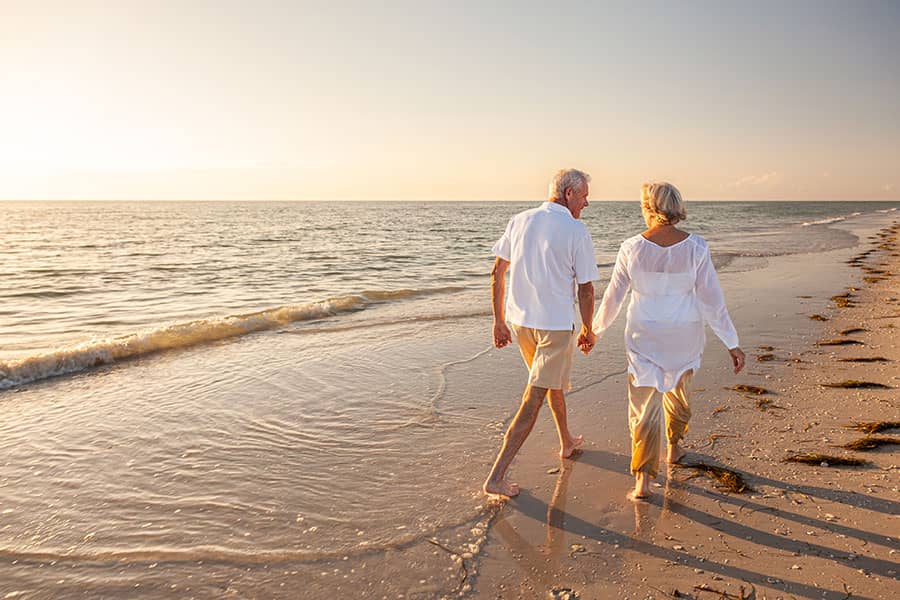 An older couple walking on the beach