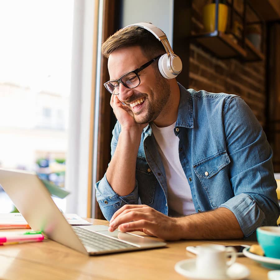 A man at a cafe using a laptop
