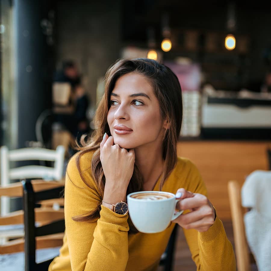 A woman at a coffee shop gazes over her shoulder