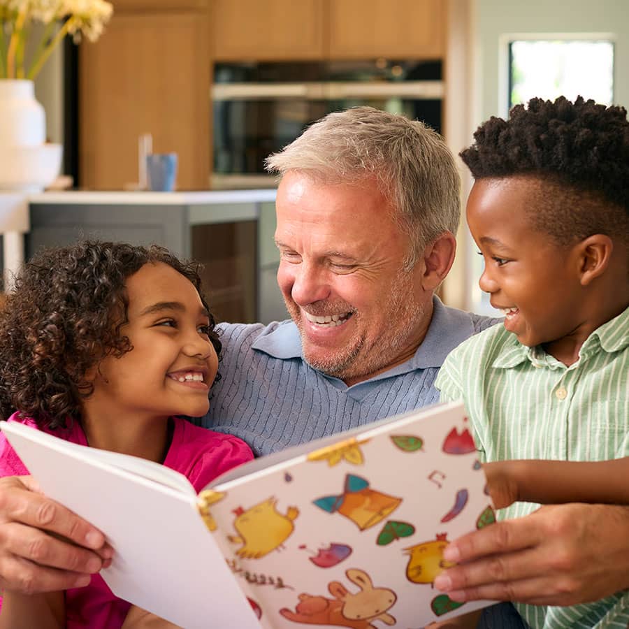 A man reads a book to his grandchildren